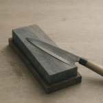 knife being sharpened with a whetstone